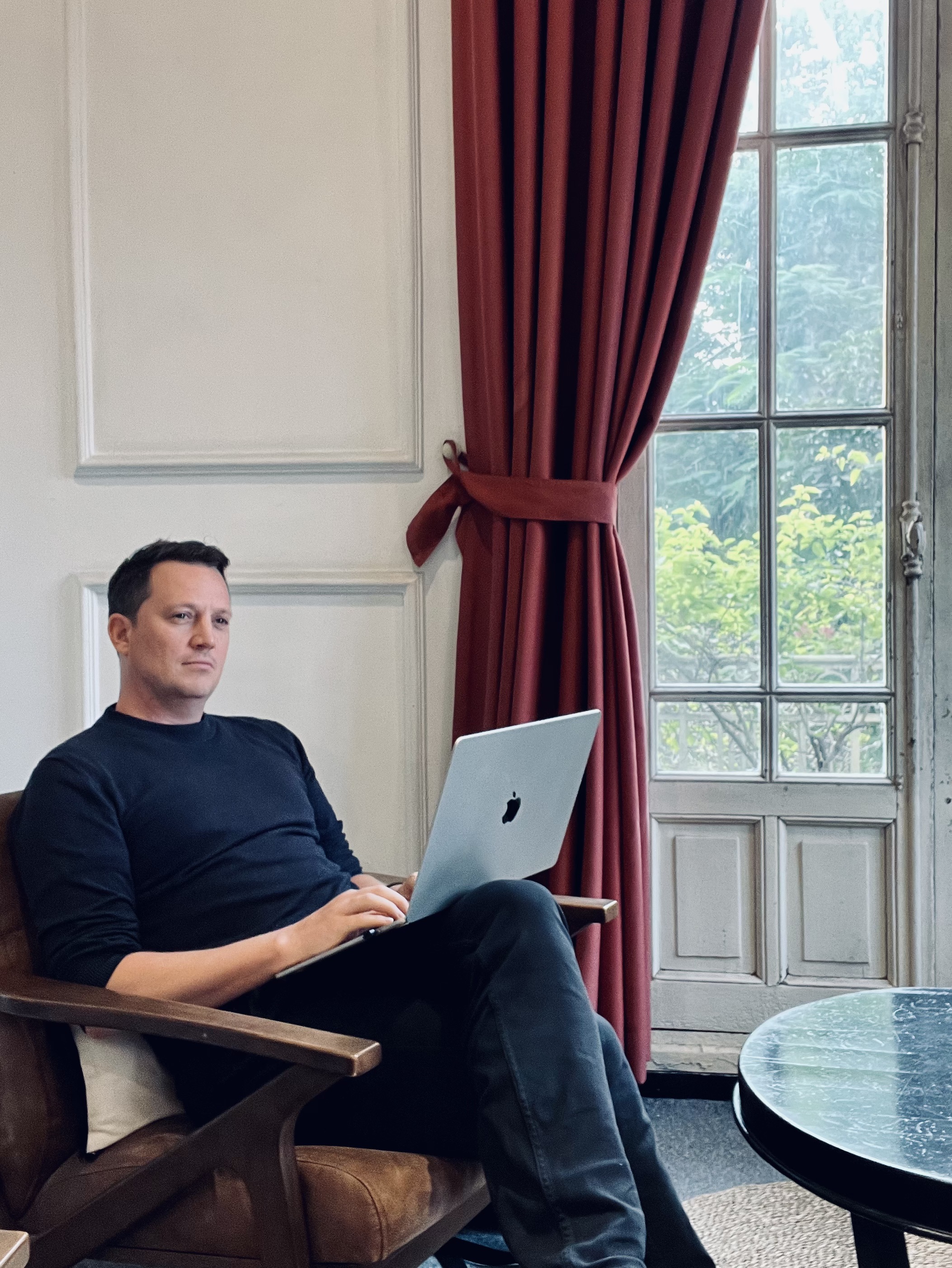 Viktor Kjellberg sitter i en fatölj med en laptop i Hanoi